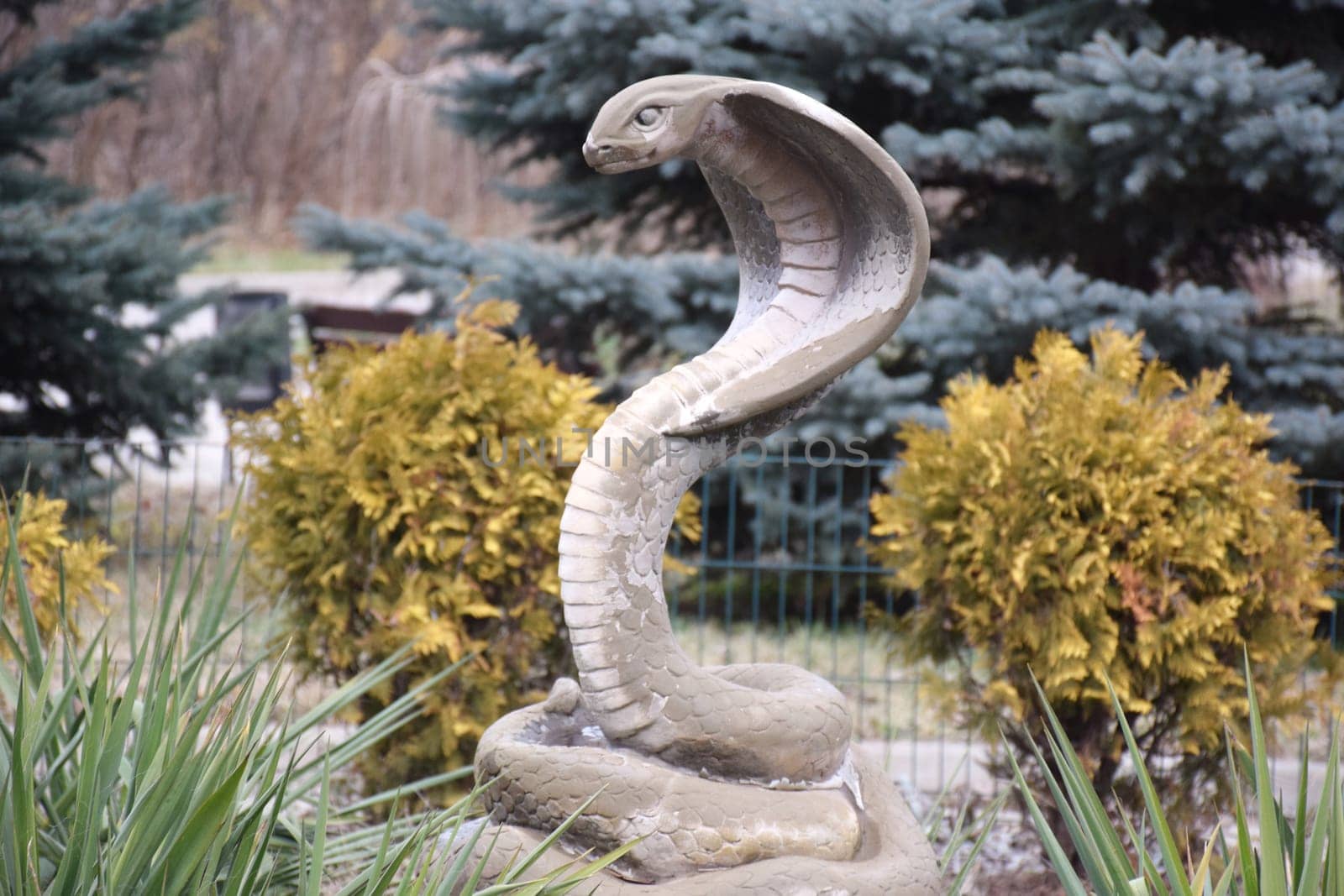 Set of snakes statues made from white stone isolated on dark by IaroslavBrylov