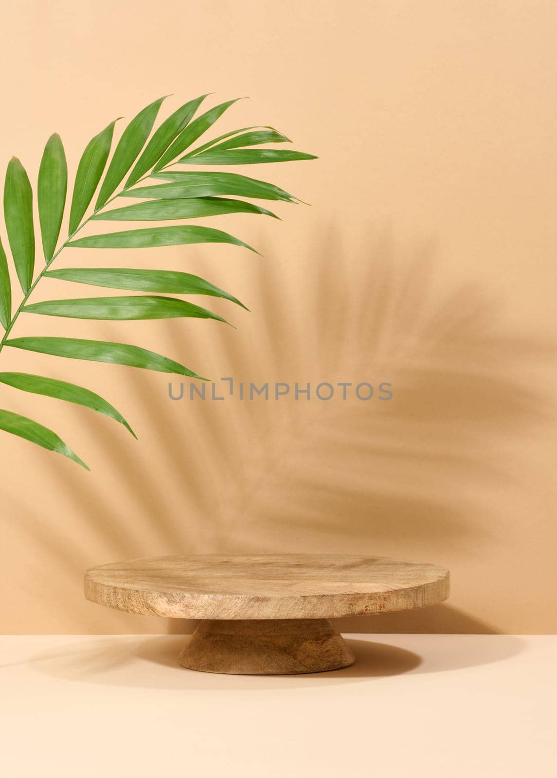 Round brown wooden stand on a beige background by ndanko