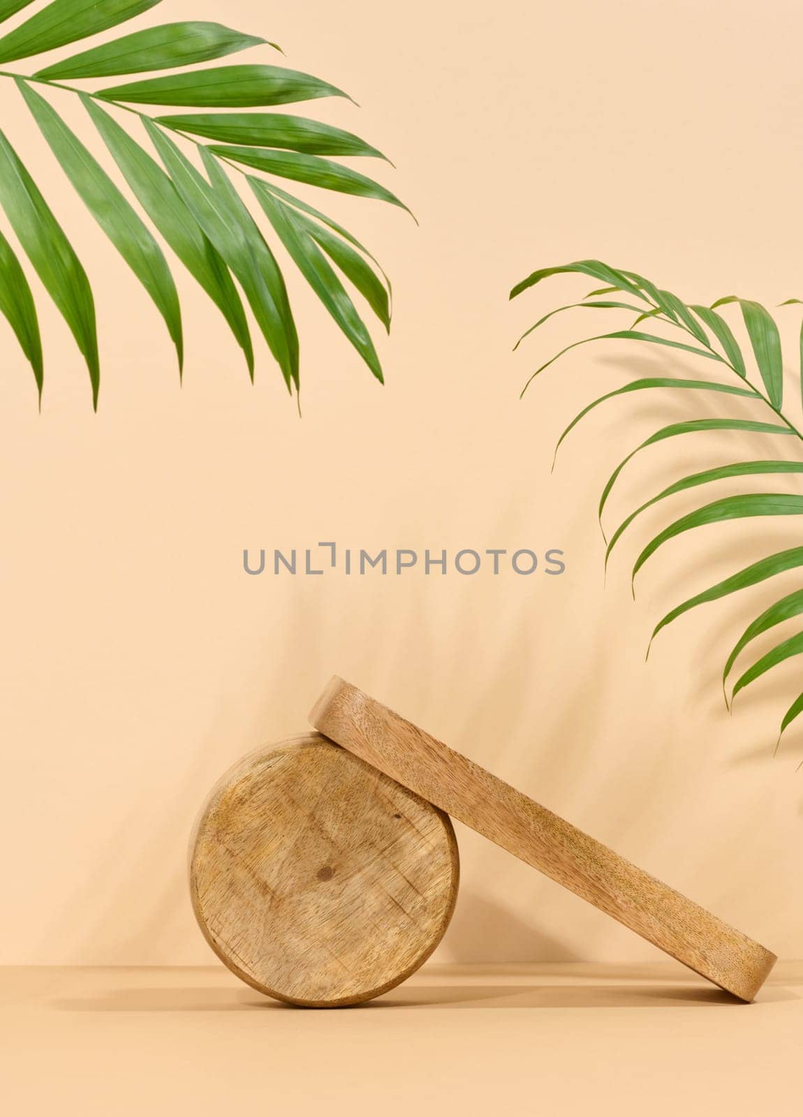 Round brown wooden stand on a beige background, a place to display cosmetics and products