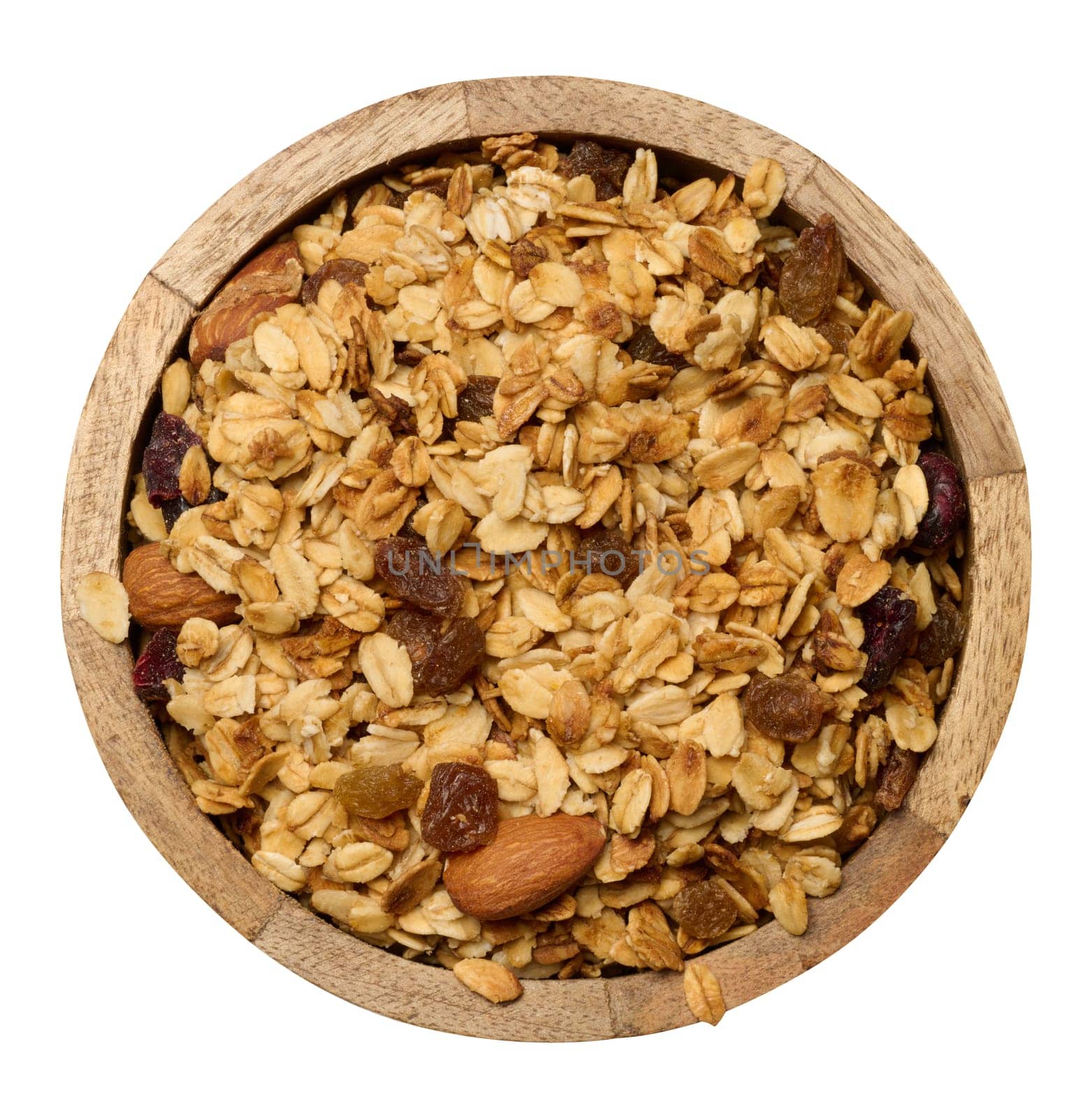 Oatmeal, raisins, cashews and almonds. Granola in wooden round plate, top view