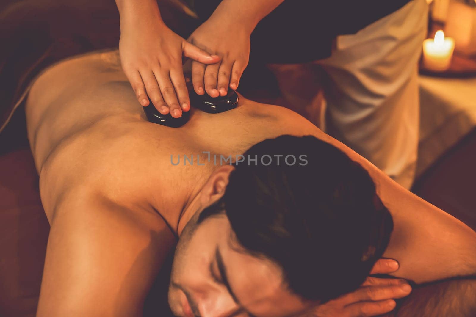 Hot stone massage at spa salon in luxury resort with warm candle light.Quiescent by biancoblue