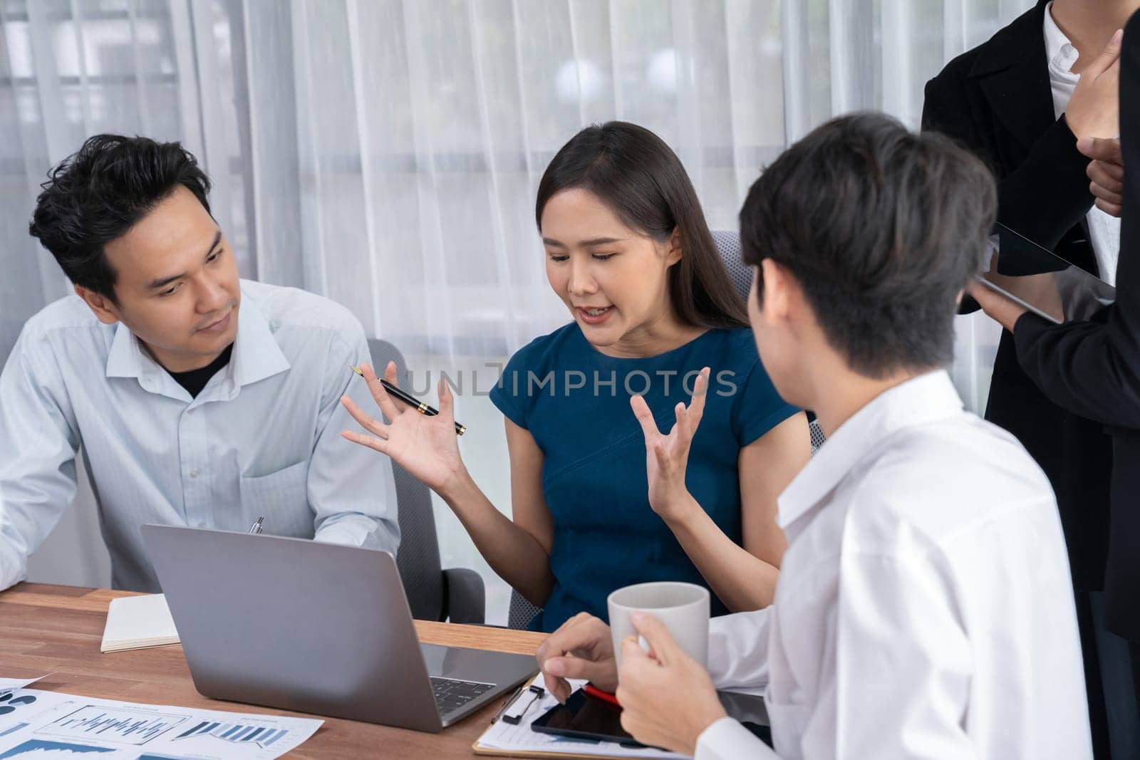 Professional Asian employee work together as team in corporate office, discussing business plans and data to achieve success on desk with laptop. Modern office worker teamwork concept. Concord