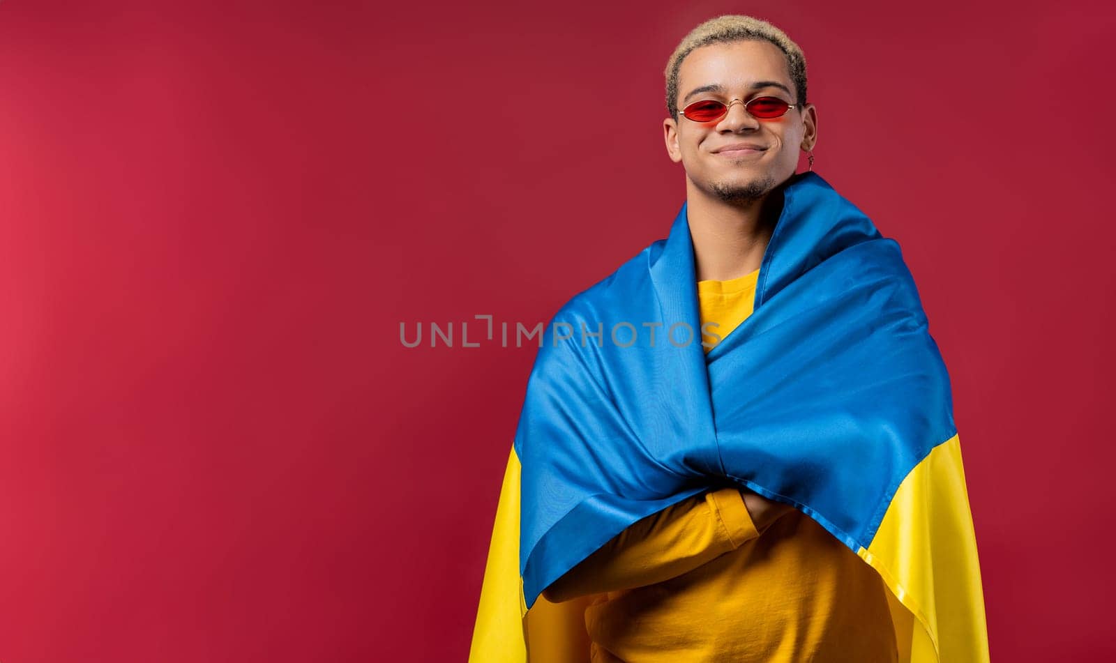 Smiling man with national Ukrainian flag. Ukraine, patriot, victory in war celebration, banner, Independence day. High quality photo