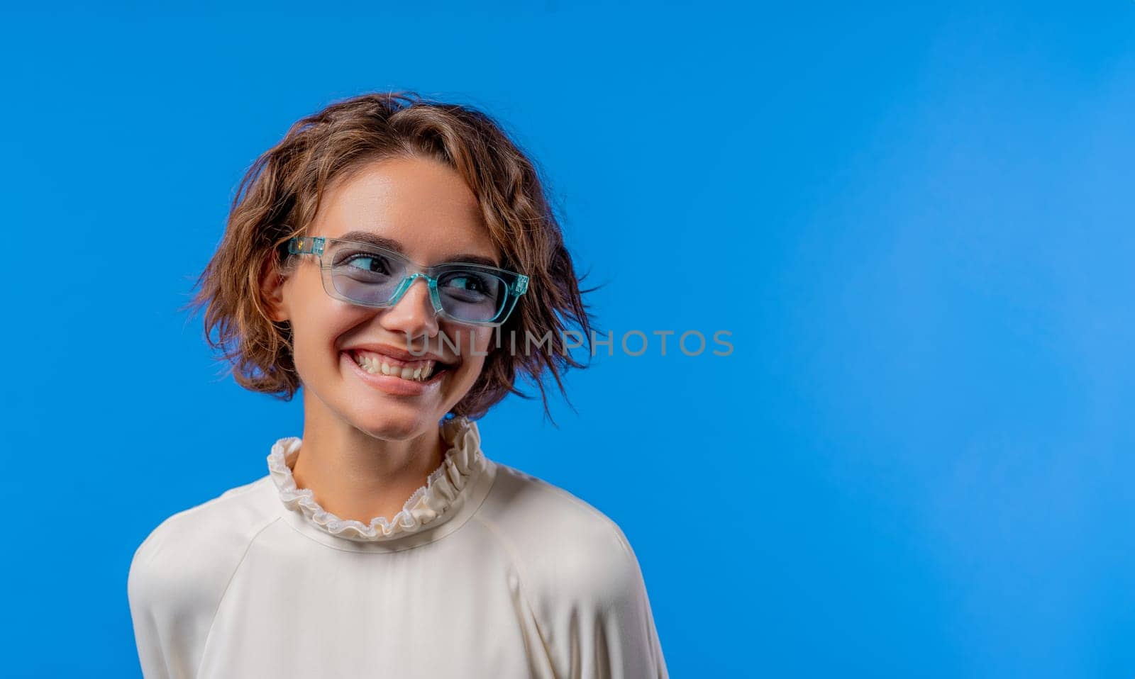 Smiling woman in transparent blue glasses. Positive stylish lady. Eyewear, sunglasses, fashion accessories. Studio background, copy space. High quality photo