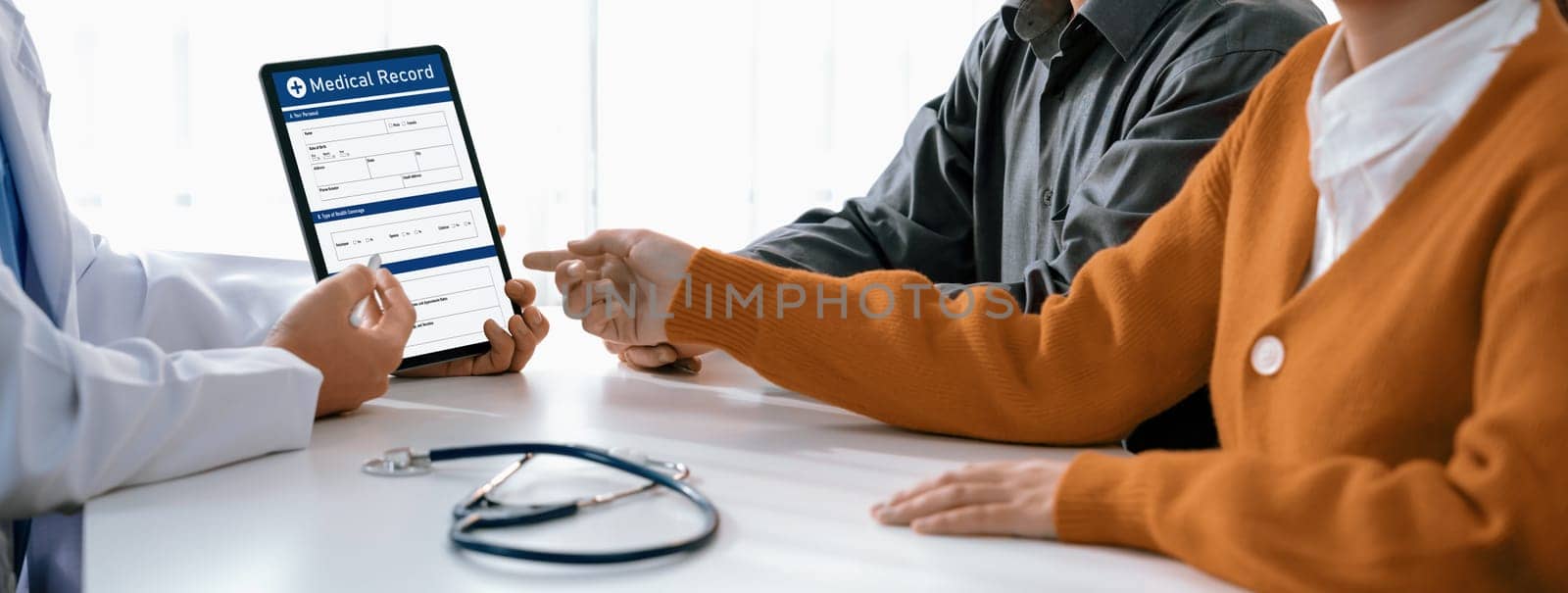 Couple attend fertility consultation with gynecologist at hospital as part family planning care for pregnancy. Loving husband and wife support each other through the doctor appointment. Panorama Rigid