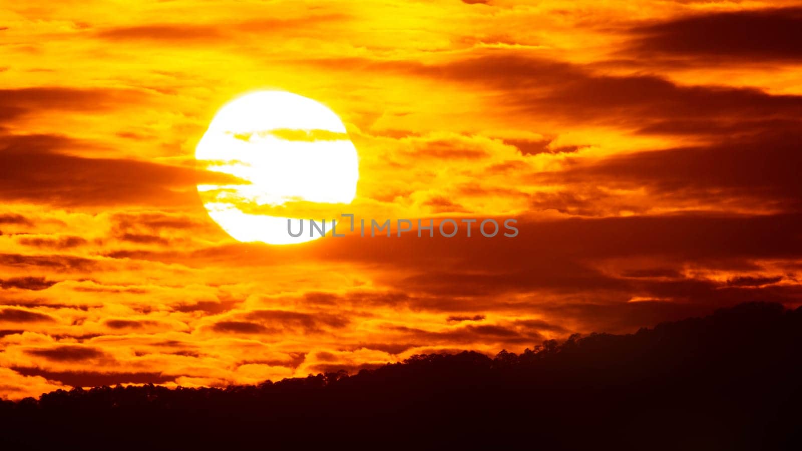 Time lapse of the beautiful sky with clouds at sunset. Sunset sky at dusk in the evening with natural sky background with golden orange clouds. by TEERASAK