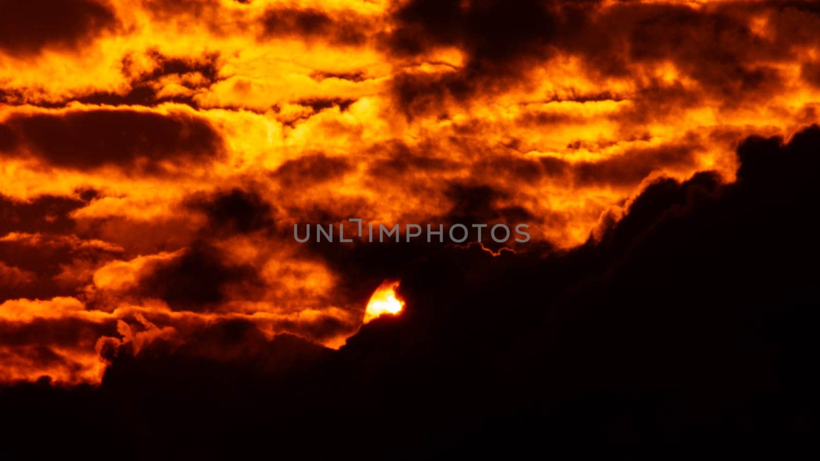 Time lapse of the beautiful sky with clouds at sunset. Sunset sky at dusk in the evening with natural sky background with golden orange clouds. by TEERASAK