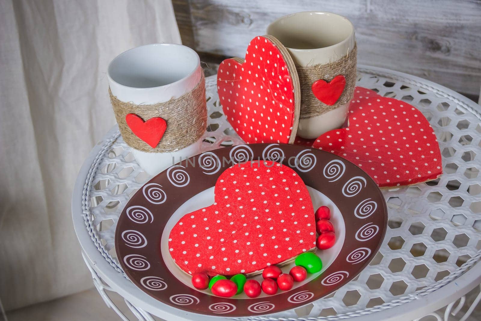 Breakfast for Valentine's Day. Heart shaped white plate with fresh strawberries, cup of coffee, gift and flowers with gift in bed. Still life composition.