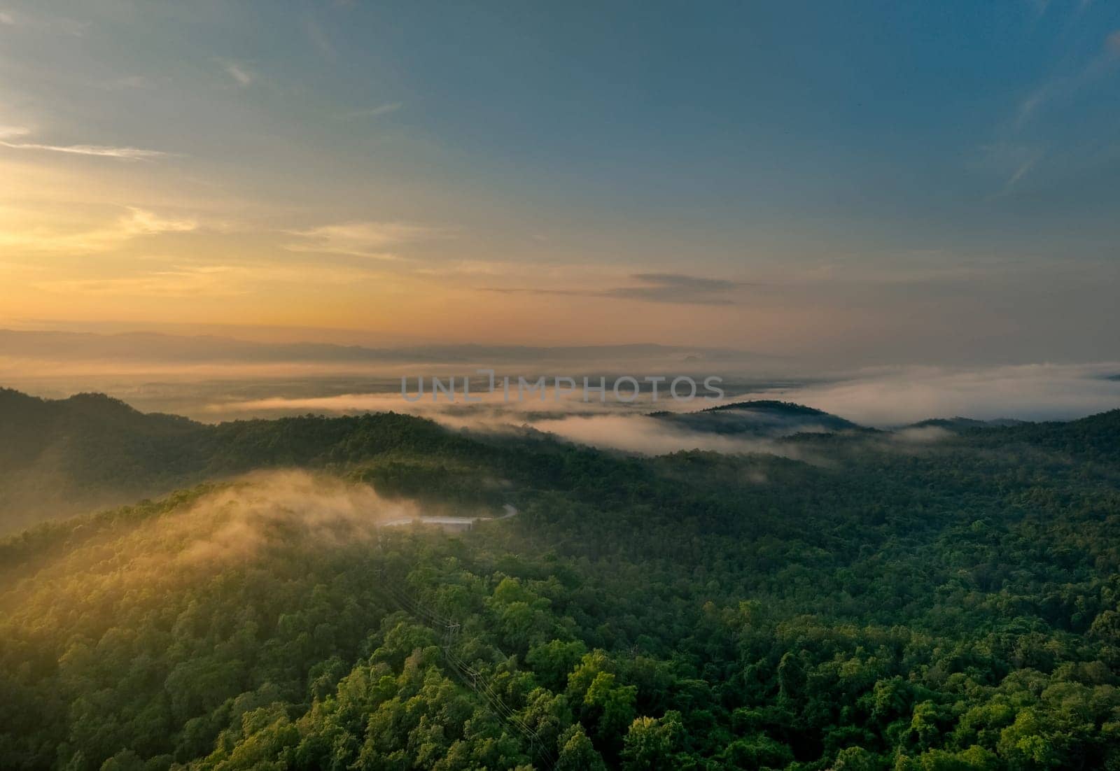 Beautiful green mountain landscape with morning sunrise sky and fog. Aerial view of green trees in tropical mountain forests and fog in winter. Nature scene of trees. Green environment background.