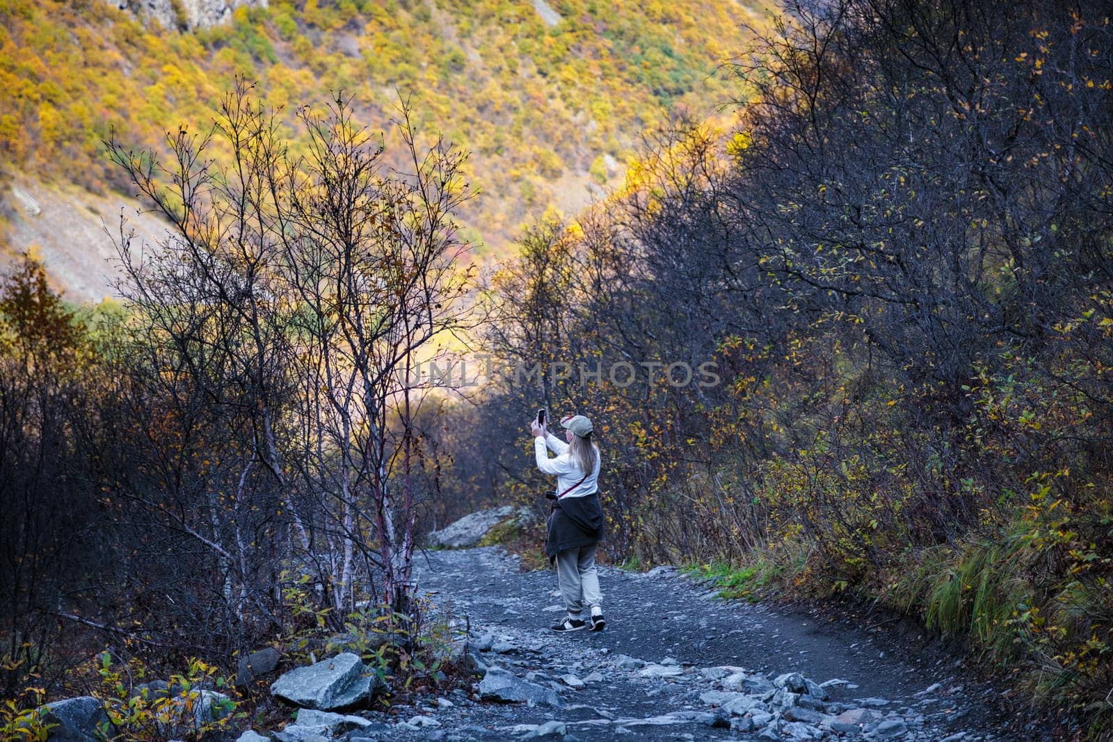 Young woman taking pictures of beautiful mountains with camera, majesty of nature and photography