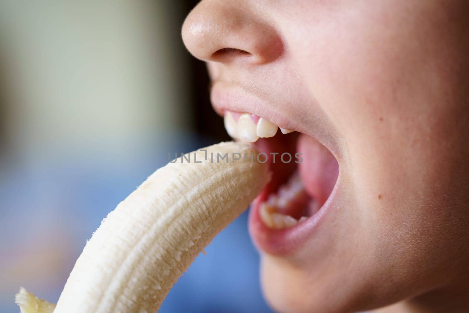 Crop girl with mouth open eating fresh peeled banana by javiindy
