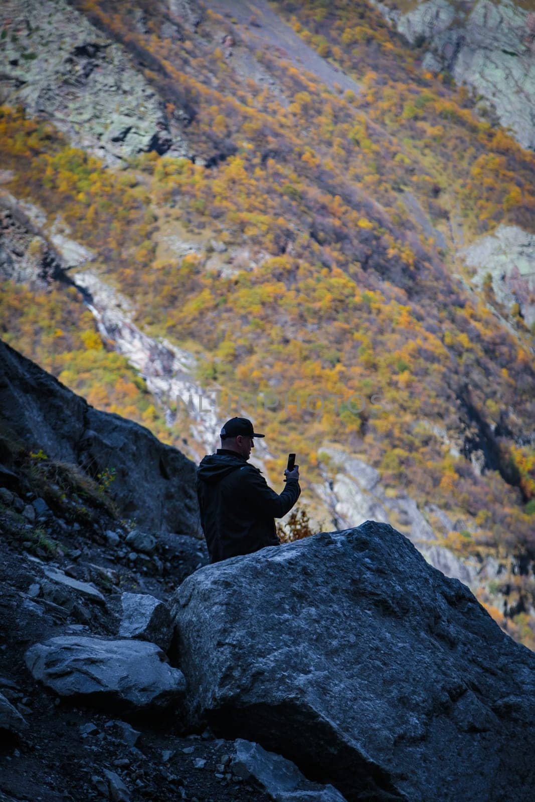 Photo of a man captured while contemplating and fixing the beauty of a mountain landscape