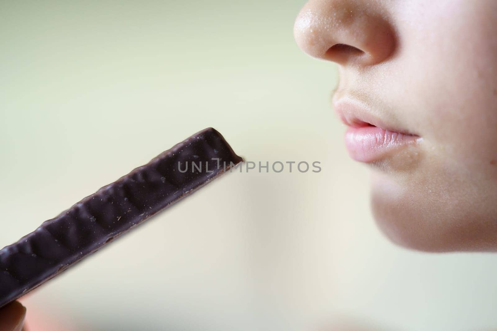 Crop unrecognizable girl with protein bar at home by javiindy