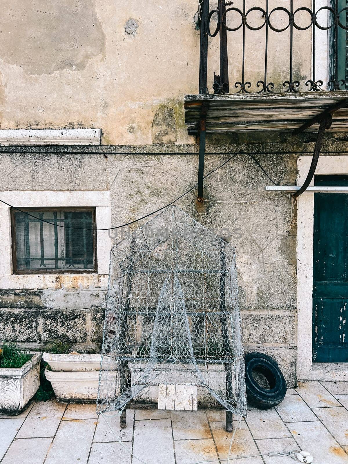 Traditional net fishing trap dries near an old stone house. High quality photo