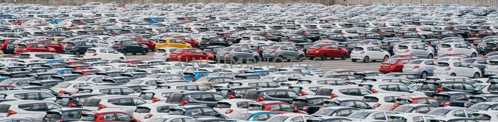 Lamchabang, Thailand - July 02, 2023 Rows of new cars grace the distribution center of a sunny car factory. A top view reveals a full parking garage bustling with industry and modern technology.