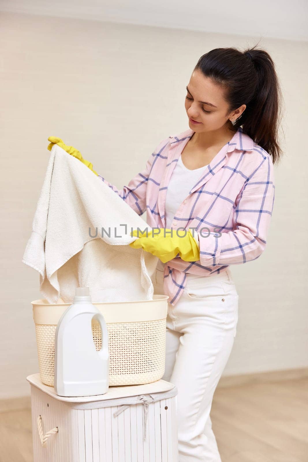 Woman is holding basket with clothes white laundry, housekeeping