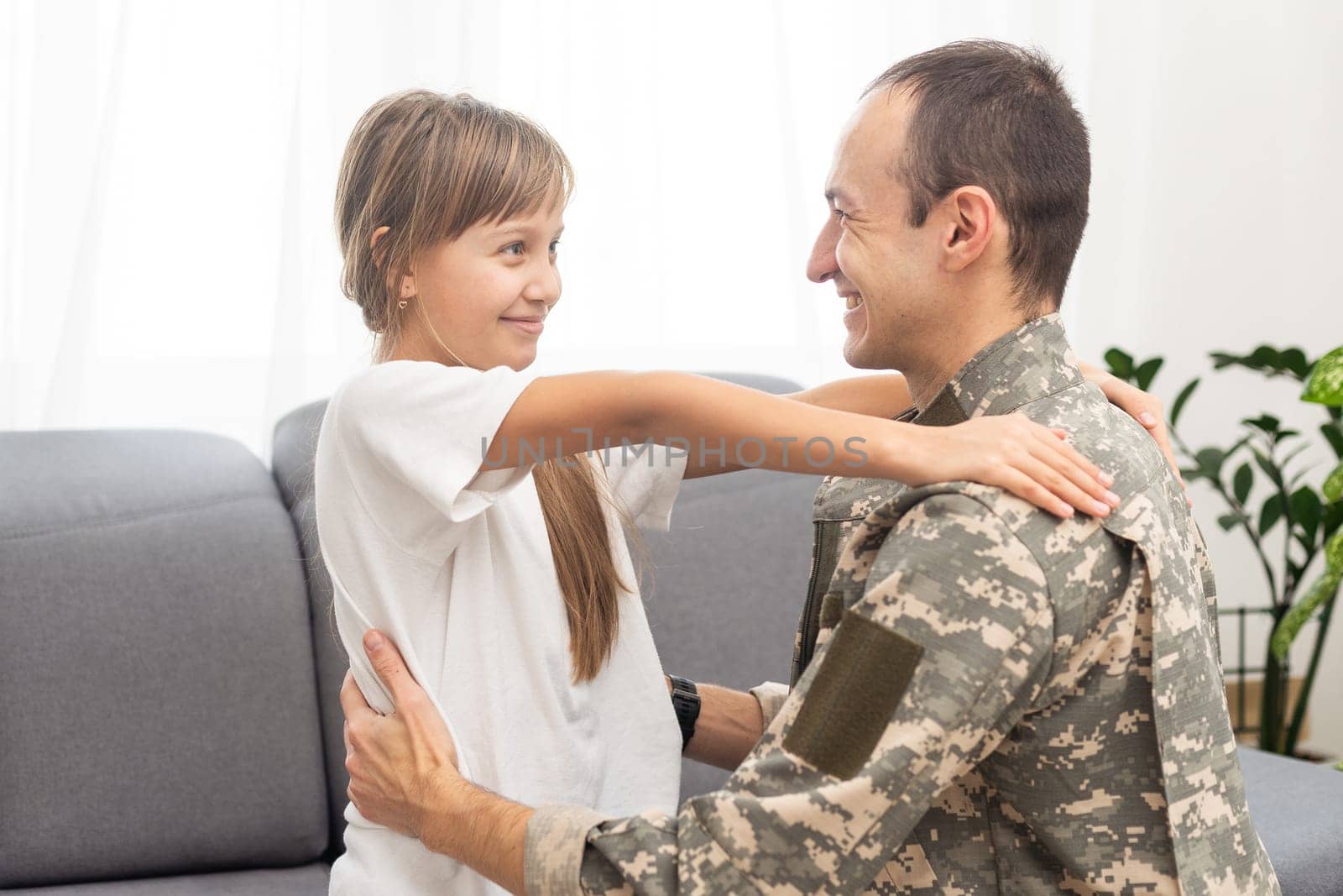 Young man in military uniform with his wife on sofa at home. High quality photo