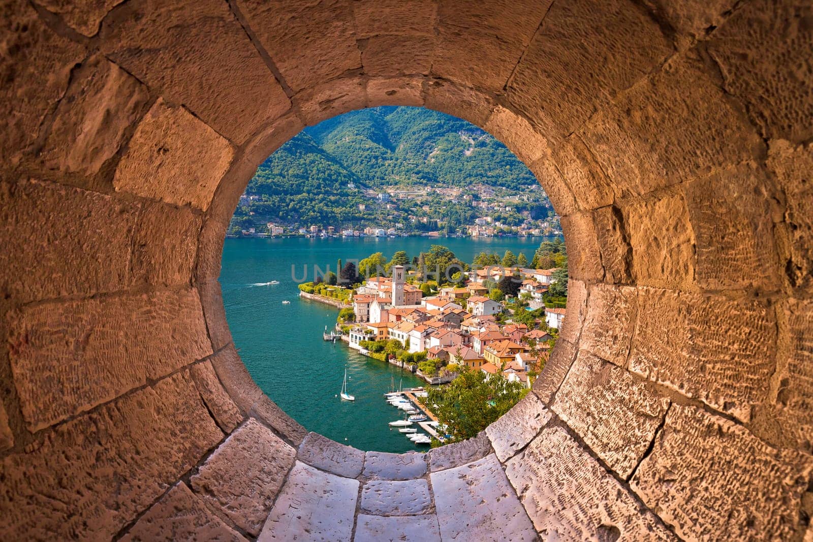Idyllic town of Torno on Como lake view through stone window, Lombardy region of Italy