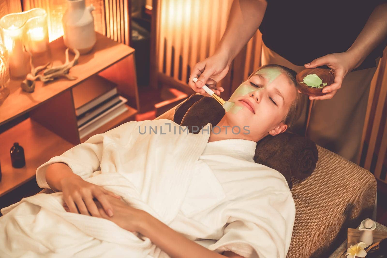 Woman indulges in rejuvenating with luxurious face cream spa massage. Quiescent by biancoblue