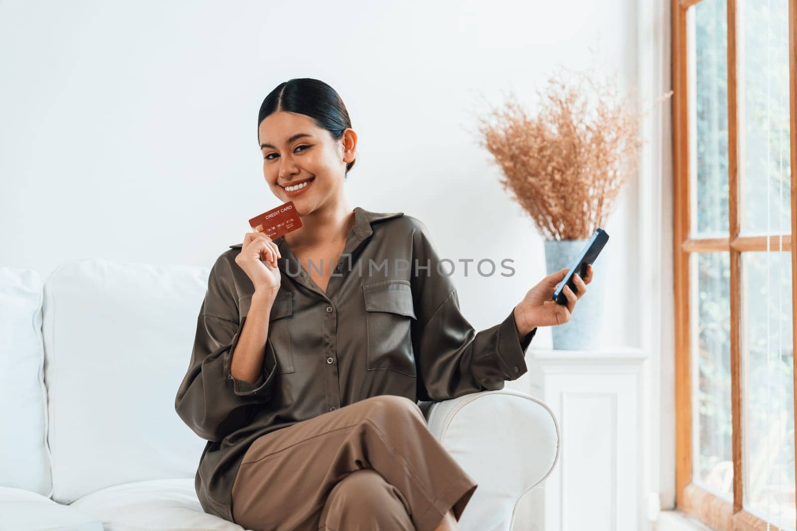 Young happy Asian woman buy product by online shopping at home while ordering items from the internet with credit card online payment protected by uttermost cyber security from online store platform