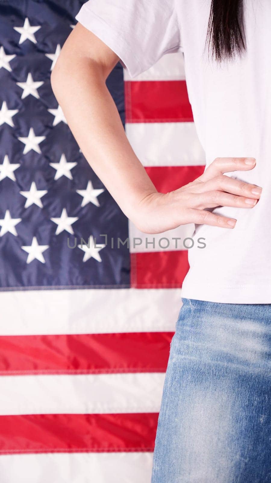 Close up of woman body and hand against american flag at 4th july. Faceless. Independence day, celebration, patriotism and holidays concept. by JuliaDorian