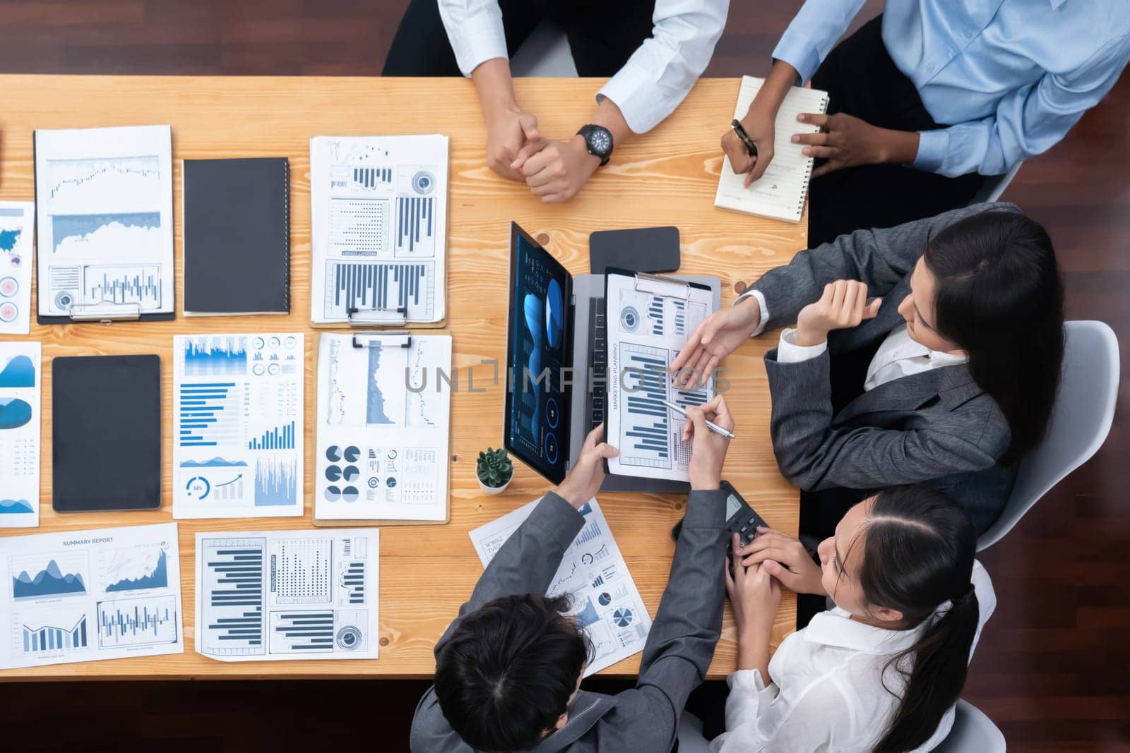 Panorama top view multiracial analyst team use BI dashboard display on laptop screen, analyzing financial data for strategic decision. Fintech analyzes marketing indicators. Concord