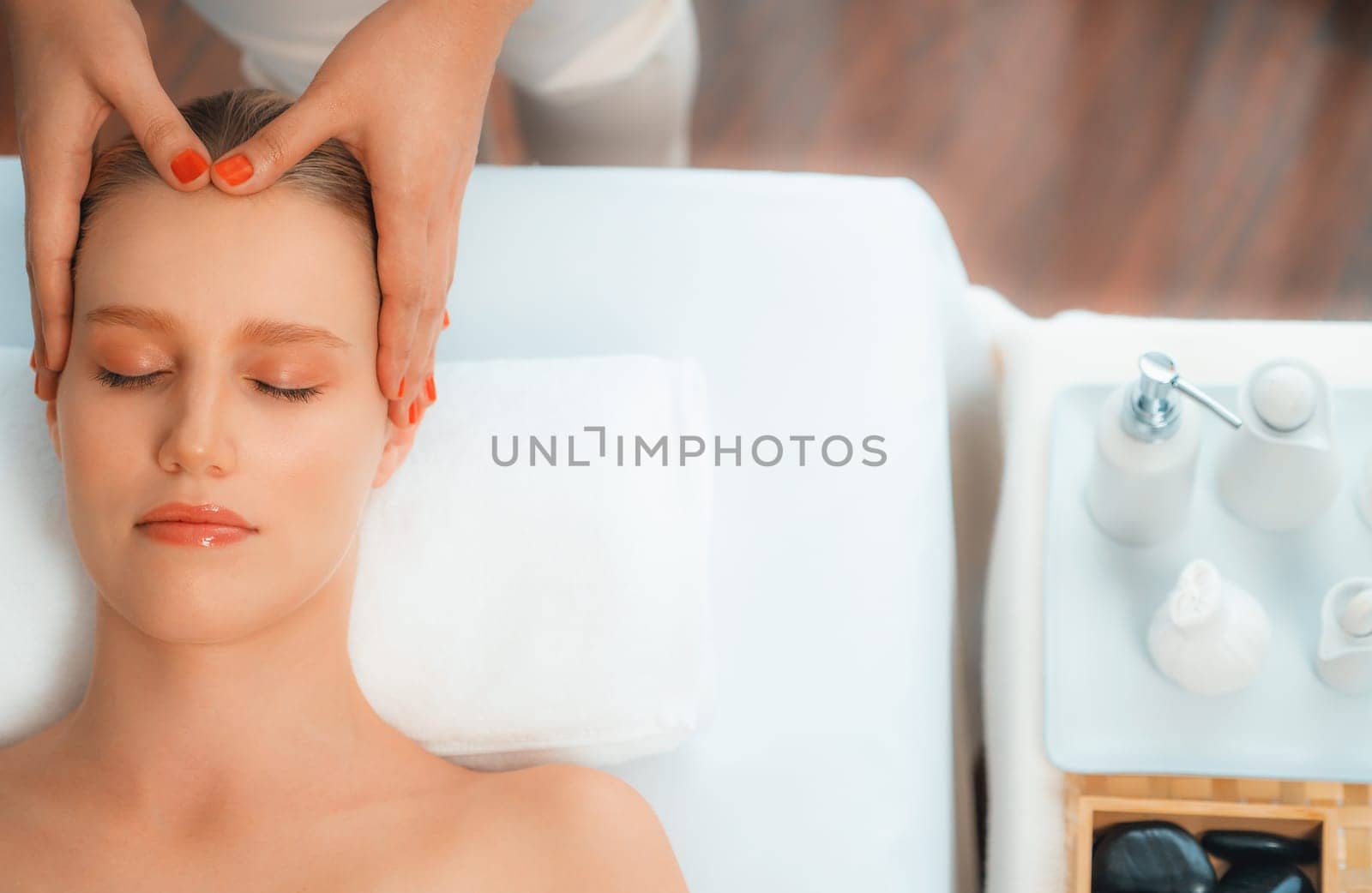 Panorama top view of woman enjoying relaxing anti-stress head massage and pampering facial beauty skin recreation leisure in dayspa modern light ambient at luxury resort or hotel spa salon. Quiescent