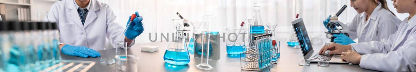 Group of dedicated scientist conduct chemical experiments and research in medical lab as groundbreaking developing for vaccine drug or antibiotic. Pharmaceutical and biochemistry laboratory. Neoteric