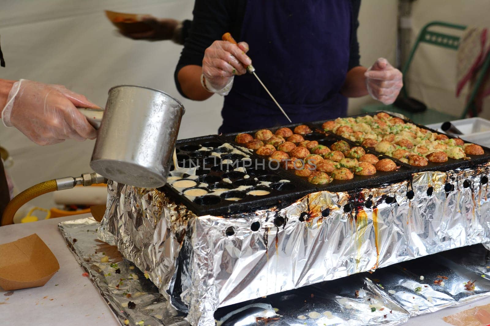 The cook pours a dough for Japanese fish balls