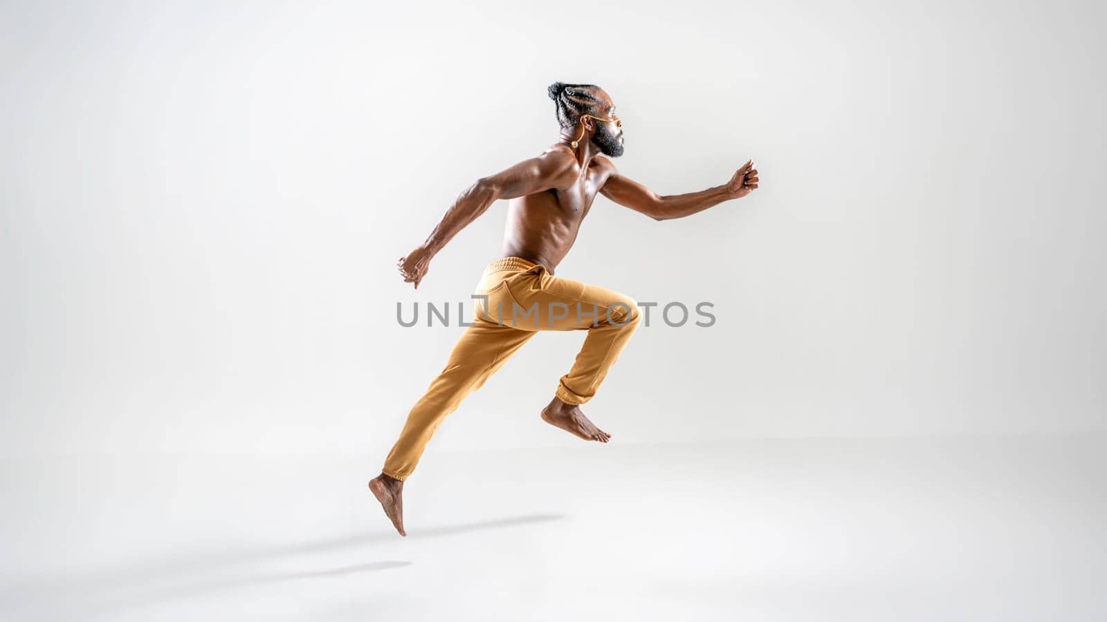 Profile side view male gay athlete runner jogging isolated on white background. Gender equality right concept. Shirtless barefoot african-american homosexual man wearing make up running. Full length