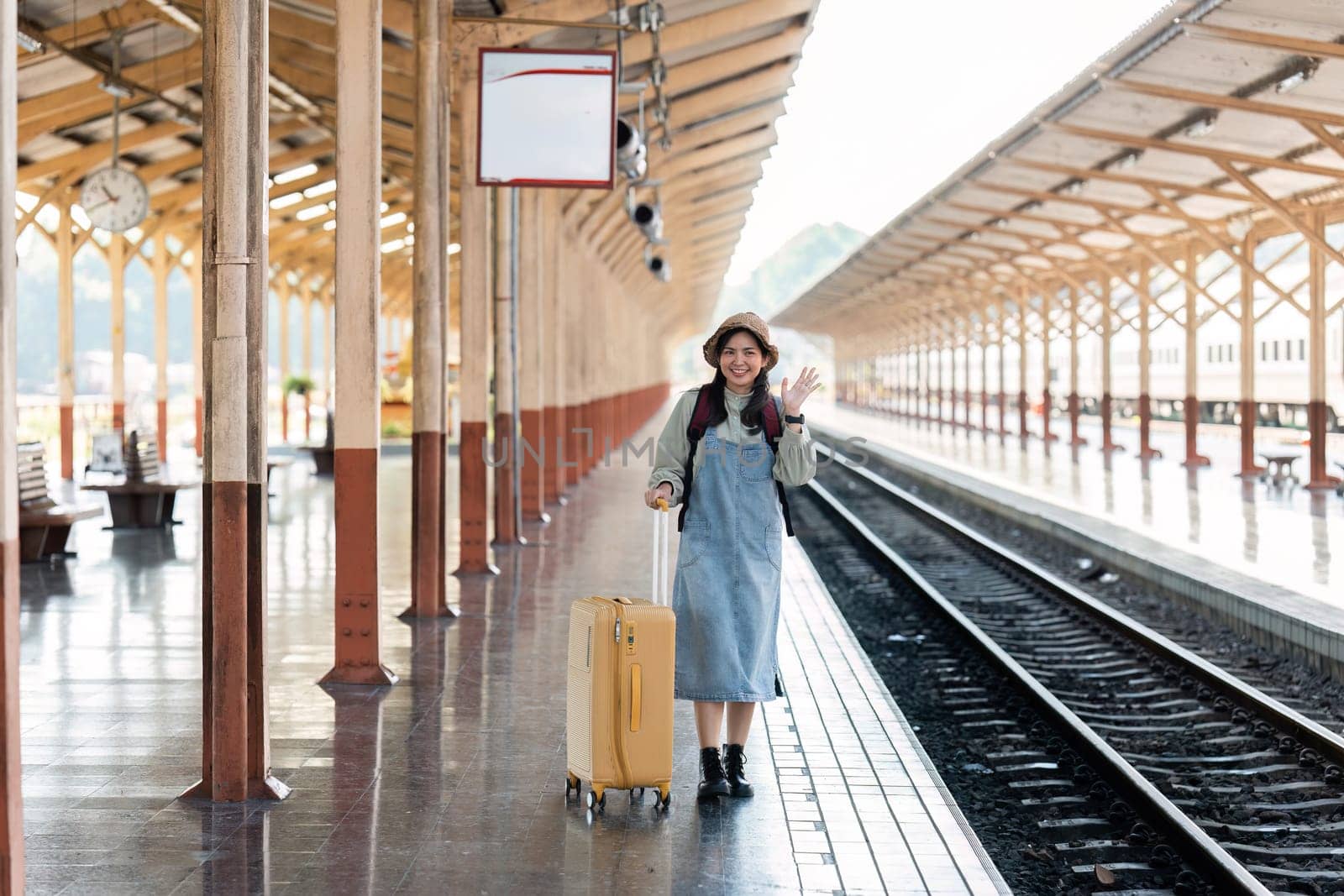 Woman traveler tourist walking with luggage at train station. Active and travel lifestyle concept.