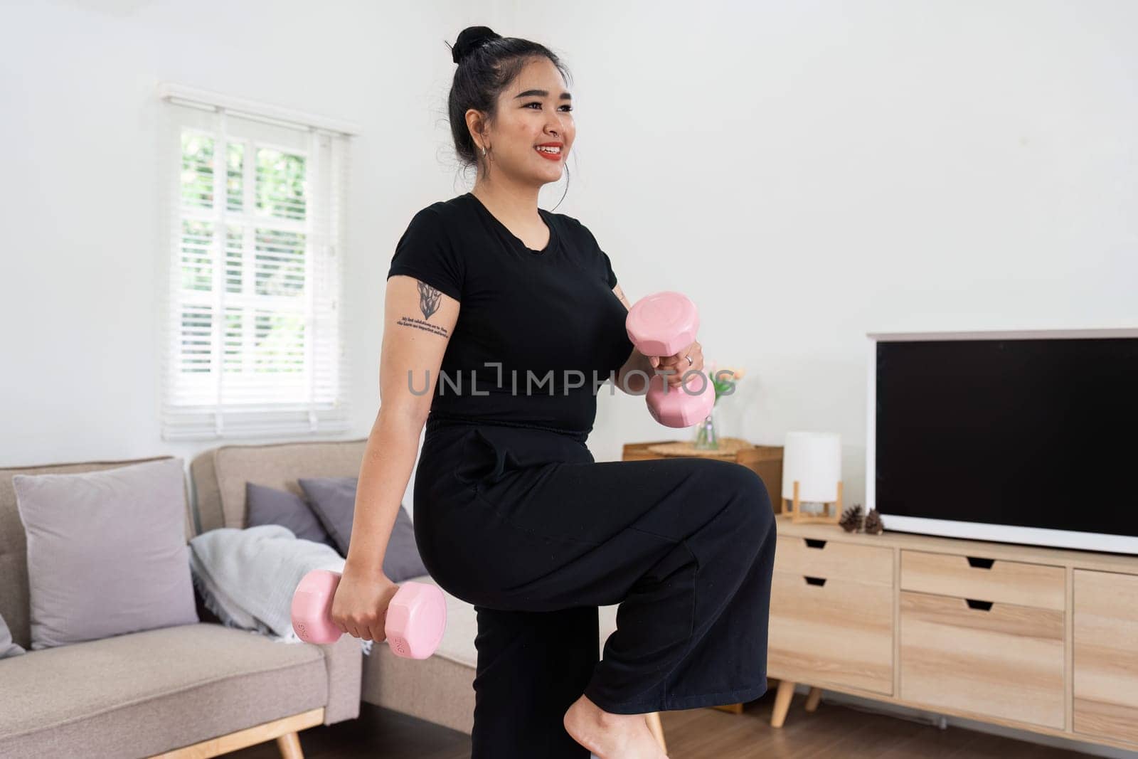 Cheerful attractive young overweight woman in activewear choosing healthy lifestyle.