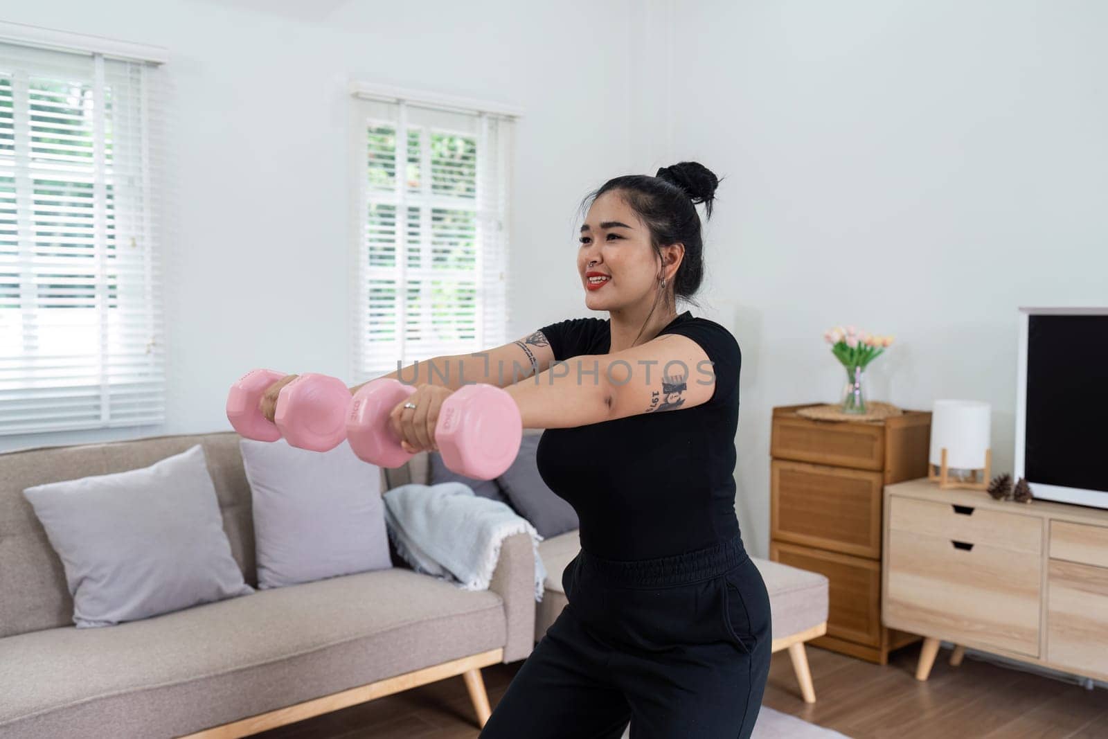 Cheerful attractive young overweight woman in activewear choosing healthy lifestyle.