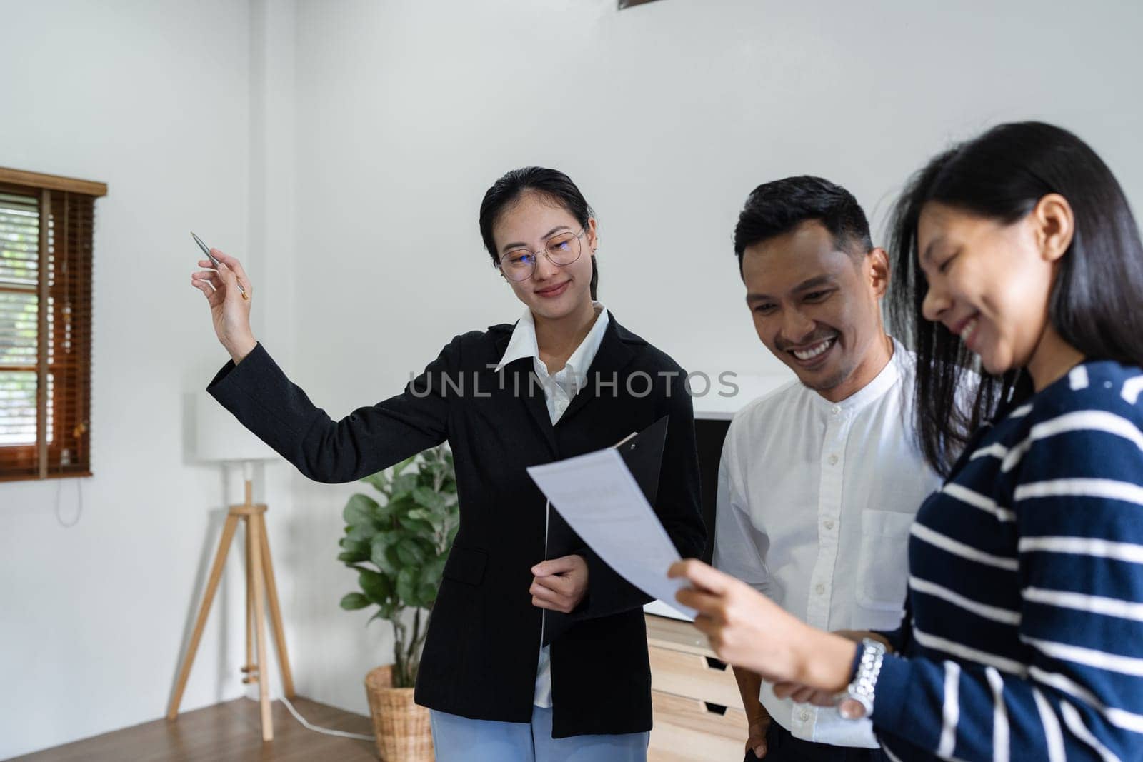 young couple with a real estate agent visiting home for buy or for rent.