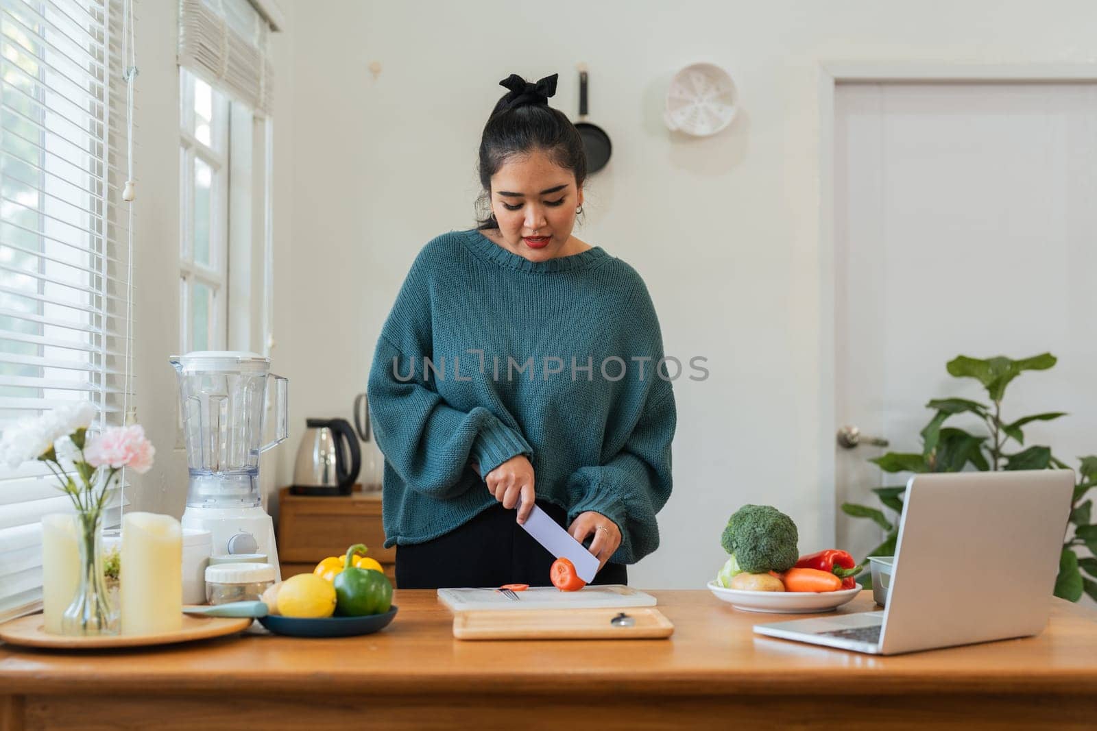 Fat woman cooking in kitchen and chopping fresh vegetables on chopping board. Learn to make salads and healthy food from online. health care concept Eat healthy food to lose weight by nateemee