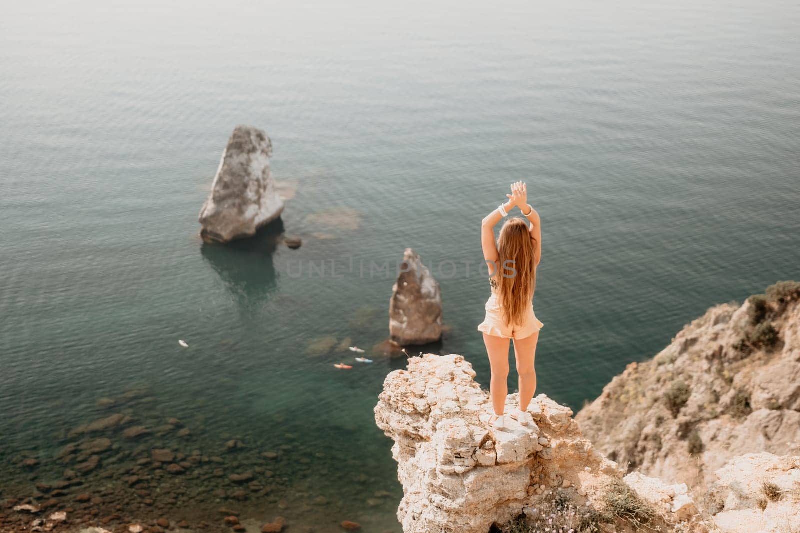 Woman travel sea. Happy tourist enjoy taking picture outdoors for memories. Woman traveler looks at the edge of the cliff on the sea bay of mountains, sharing travel adventure journey by panophotograph