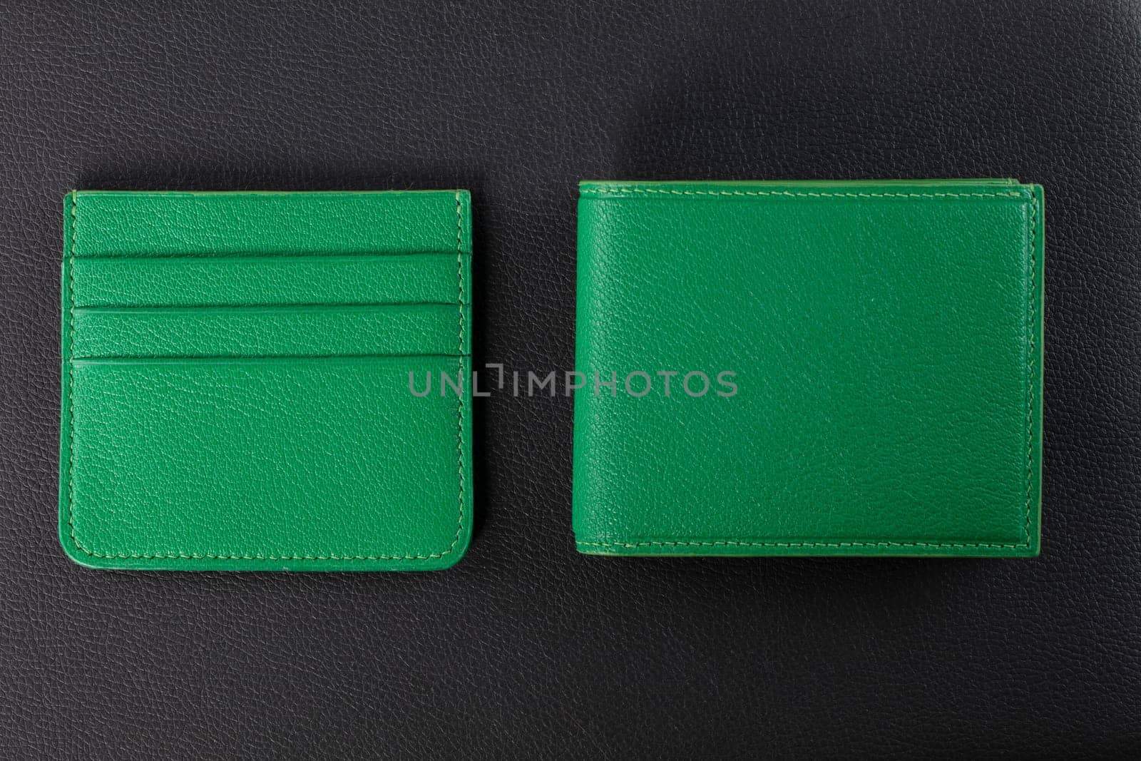 Leather products. Wallet business card holder made of green leather on a black background. by Sviatlana