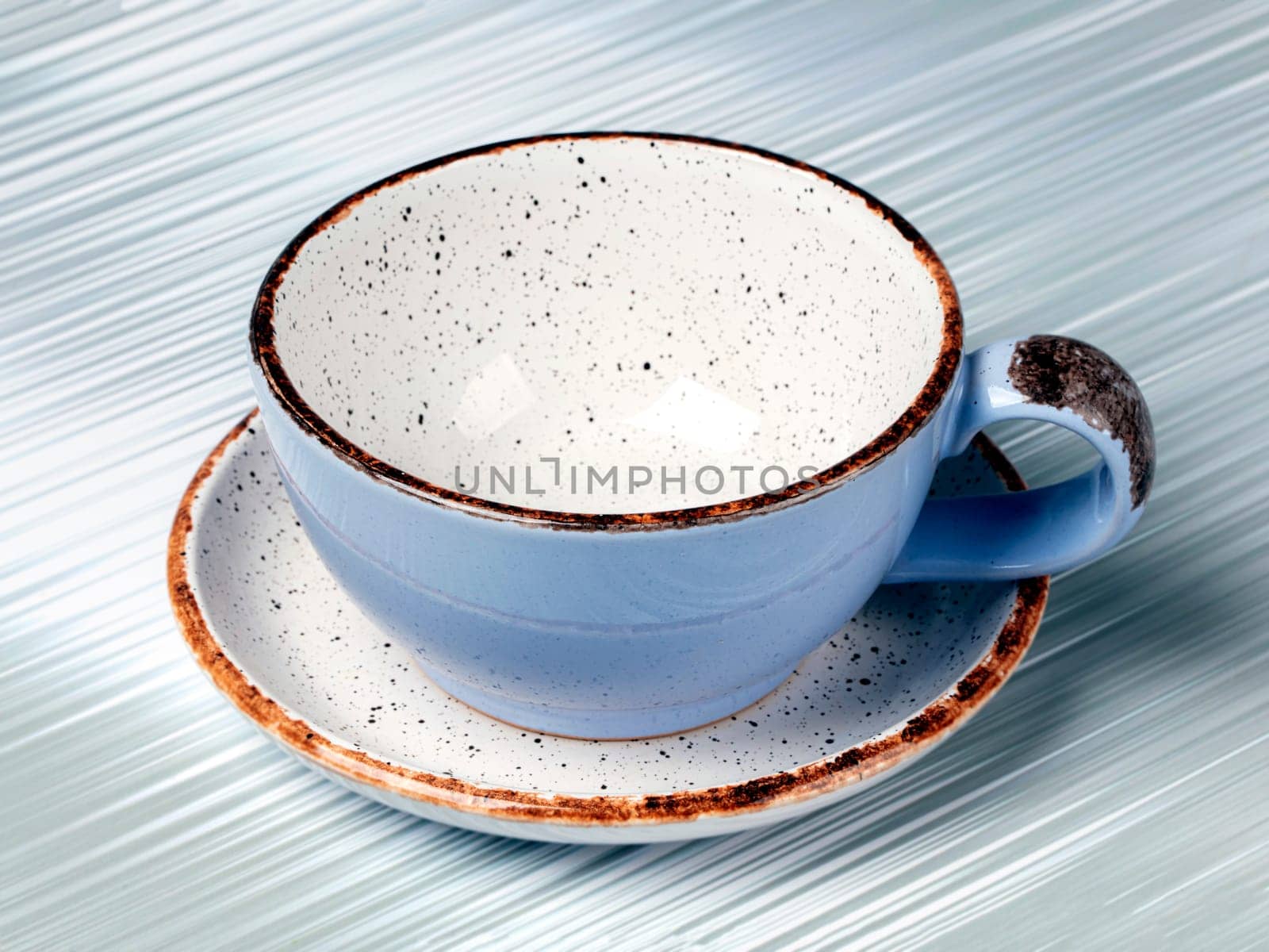 Empty blue ceramic cup on a gray background.