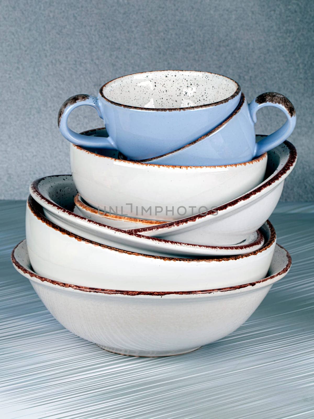 Ceramic bowls and cups are stacked on top of each other.