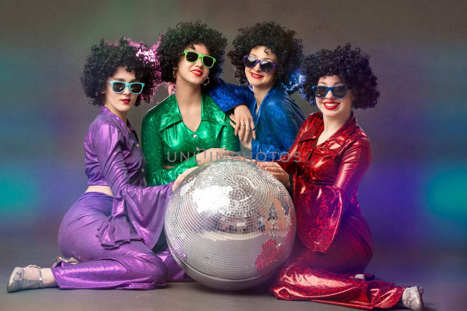 Group of happy girls in disco style, with disco ball, halloween party, on gray background. 80s themed party. by Sviatlana