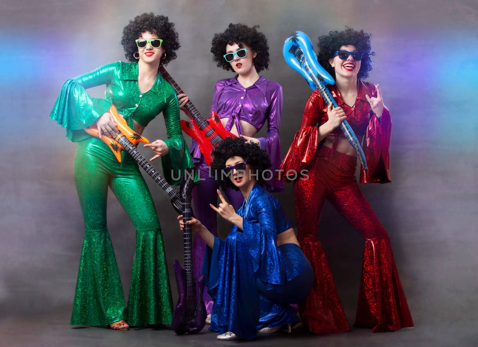 Girls in colorful shiny costumes and African wigs with guitars. Vintage music disco band for women. by Sviatlana