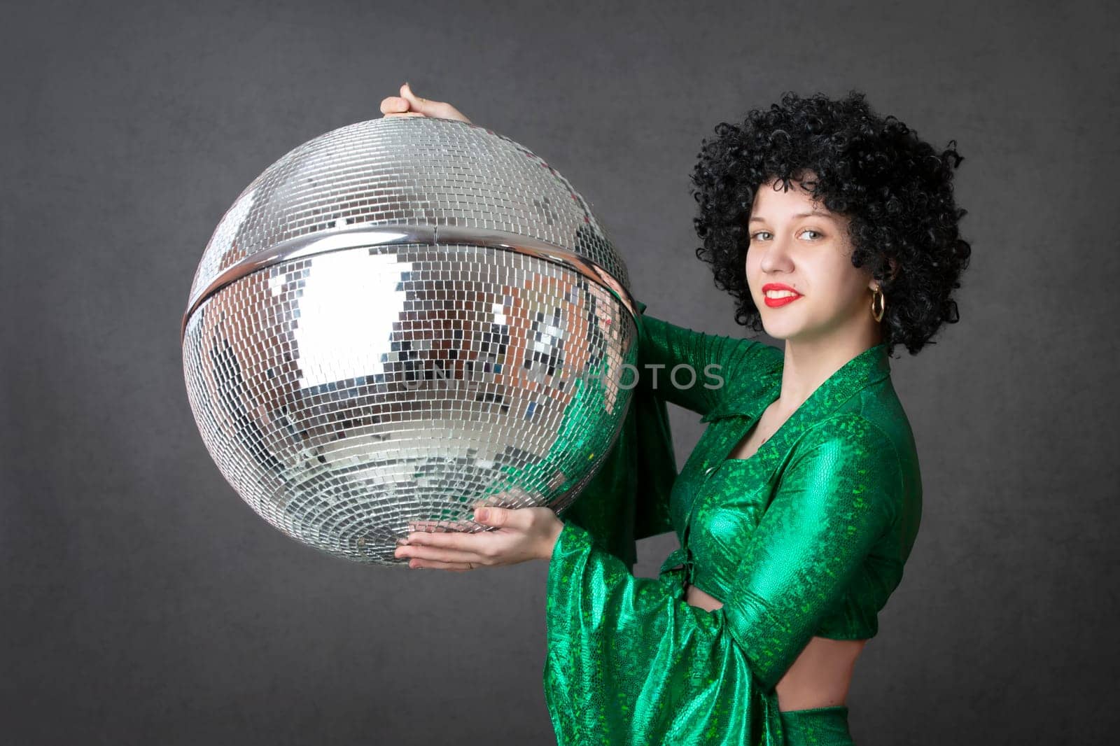 Happy girls in disco style, with disco ball, halloween party, on gray background. 80s themed party.