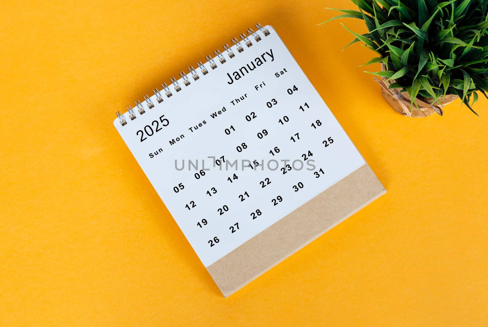 January 2025 desk calendar on yellow background. Directly above. Flat lay. Copy space.