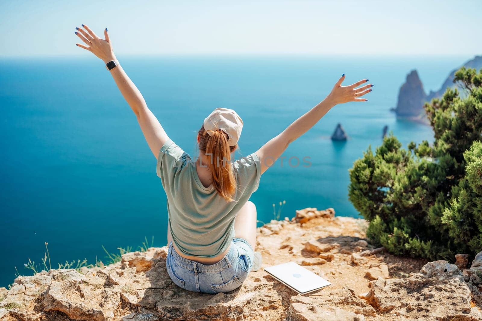 Woman tourist sky sea. Happy traveller woman in hat enjoys vacation raised her hands up.