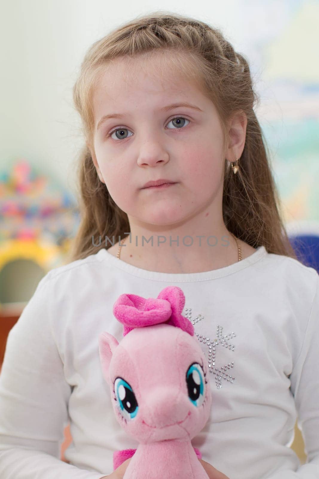 Belarus, Gomel, May 29, 2018. The kindergarten is central. Open Day.Portrait of a preschool girl with a soft toy horse by Sviatlana