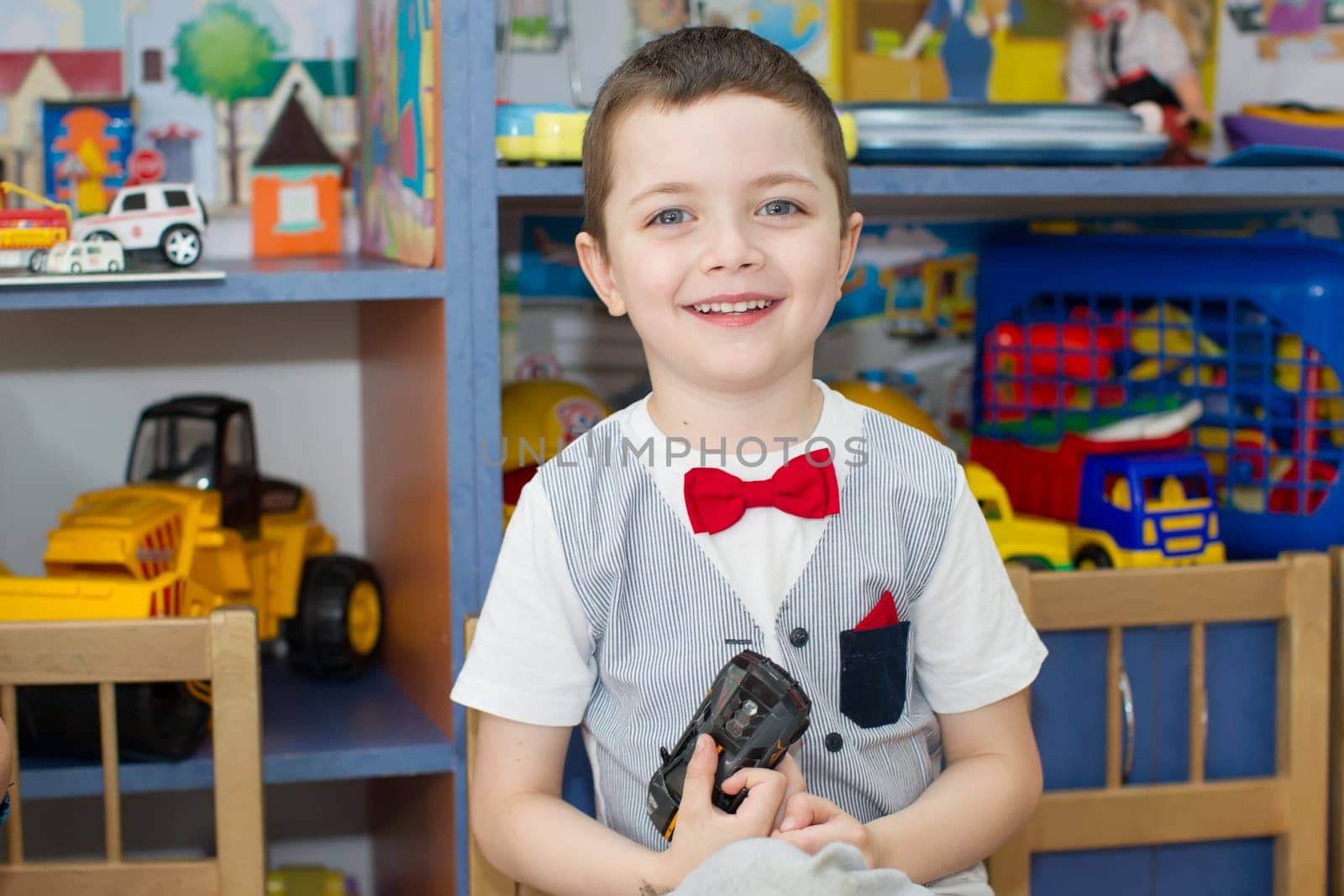 Belarus, Gomel, May 29, 2018. The kindergarten is central. Open Day.Smiling preschool boy on toys background.Satisfied child in kindergarten