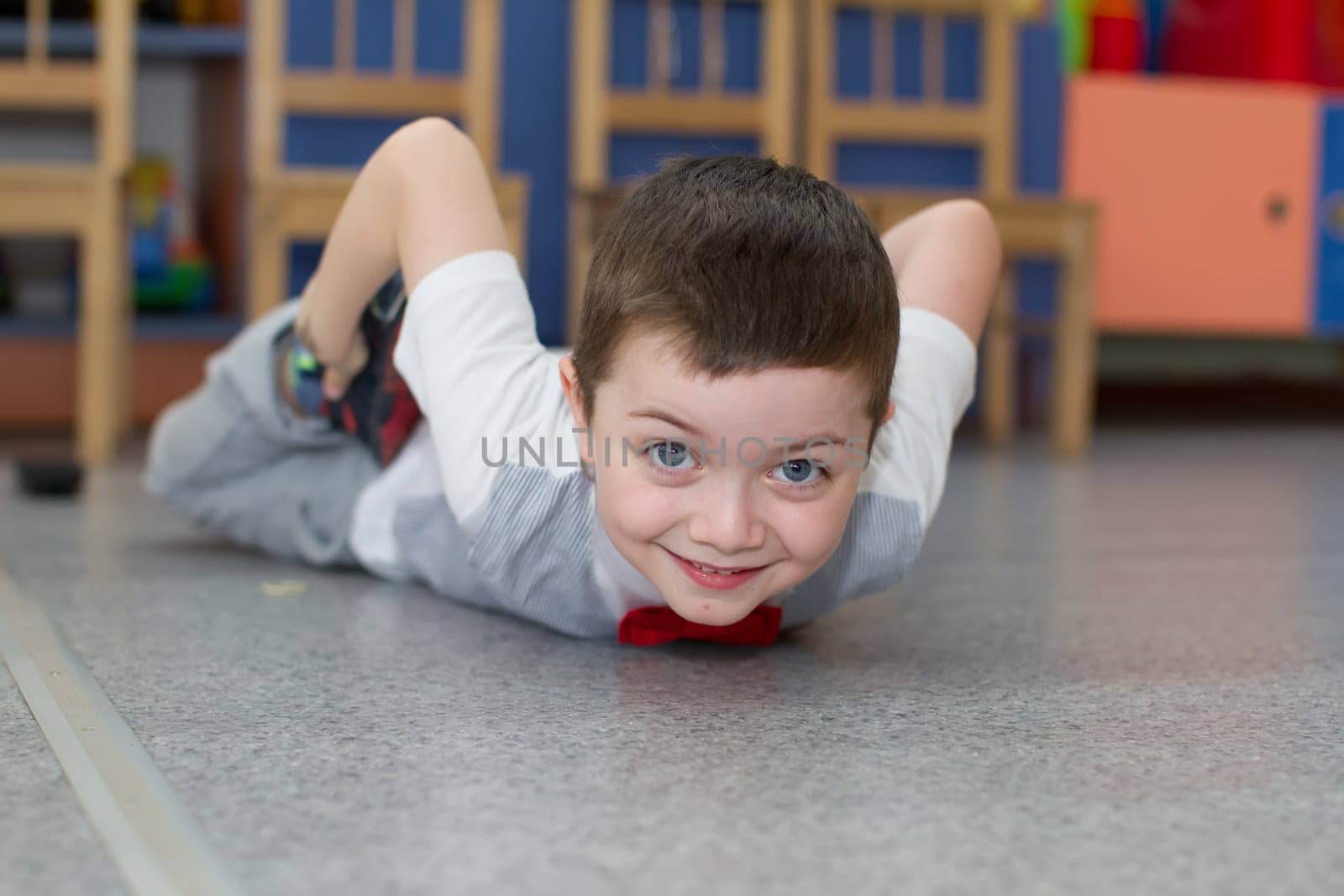 Belarus, Gomel, May 29, 2018. The kindergarten is central. Open Day.Boy preschooler doing exercises.The child lies on the floor