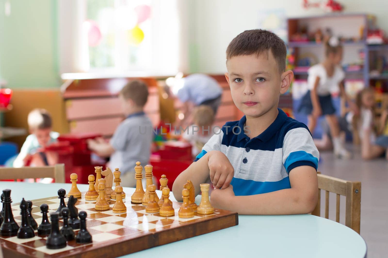 Belarus, Gomel, May 29, 2018. The kindergarten is central. Open Day.Boy playing chess in kindergarten by Sviatlana