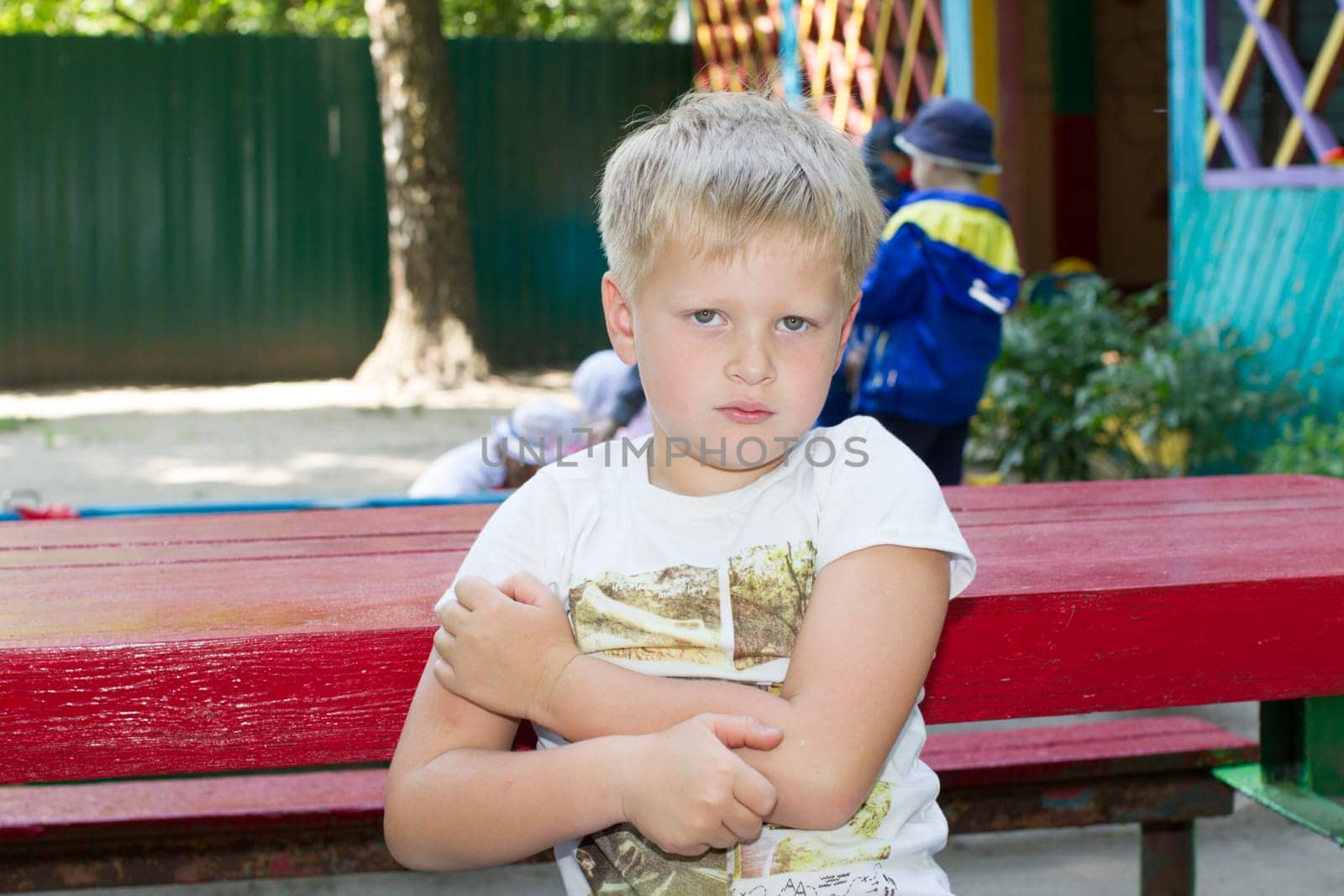 Belarus, Gomel, May 29, 2018. The central kindergarten. Open day.Sad boy preschool boy on bench by Sviatlana