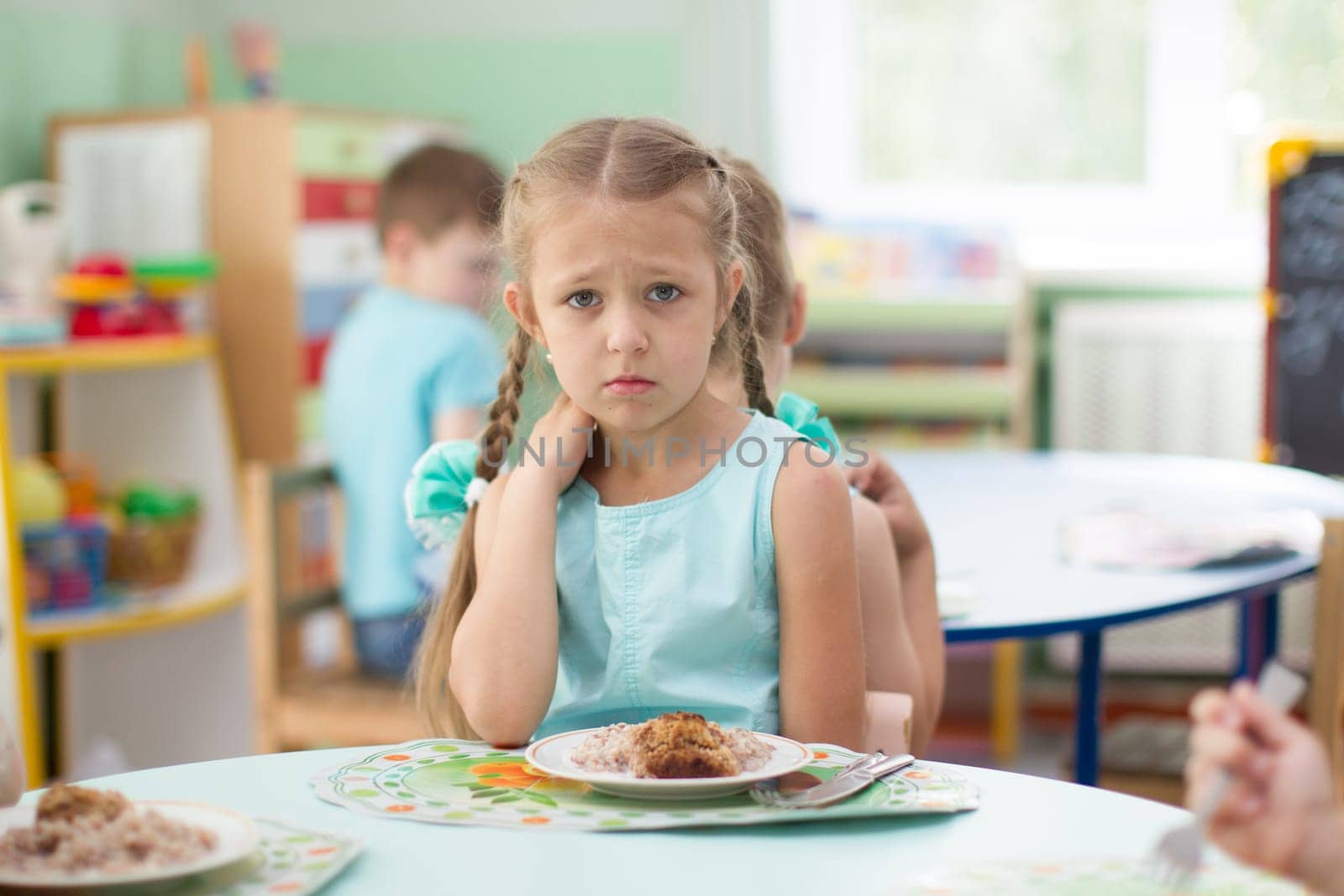 Belarus, Gomel, May 29, 2018. The kindergarten is central. Open Day.The child eats in a kindergarten.Poor appetite.The child does not want to eat food by Sviatlana
